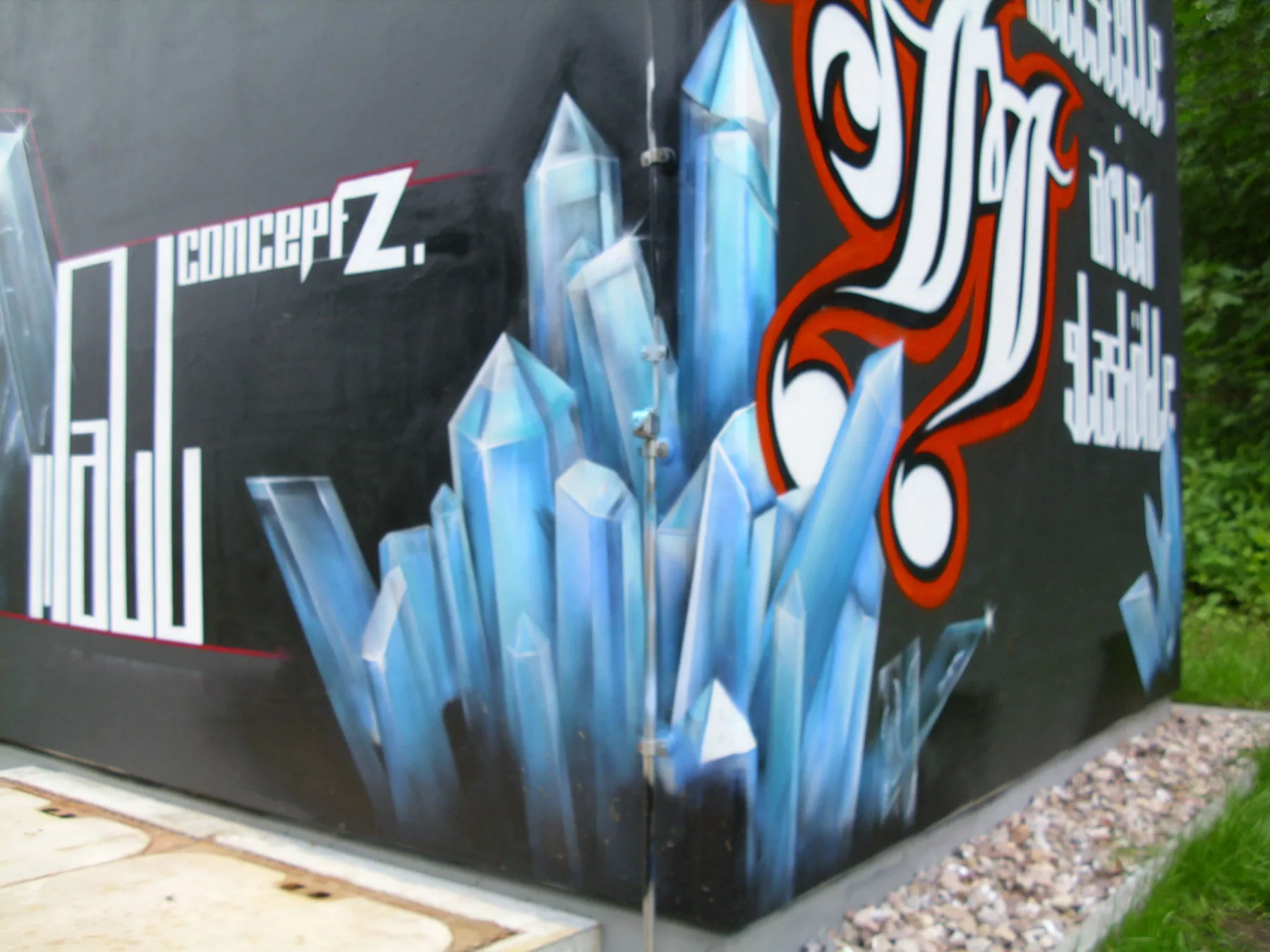 Graffiti mit Kristallformen und typografischen Elementen an einer Außenwand